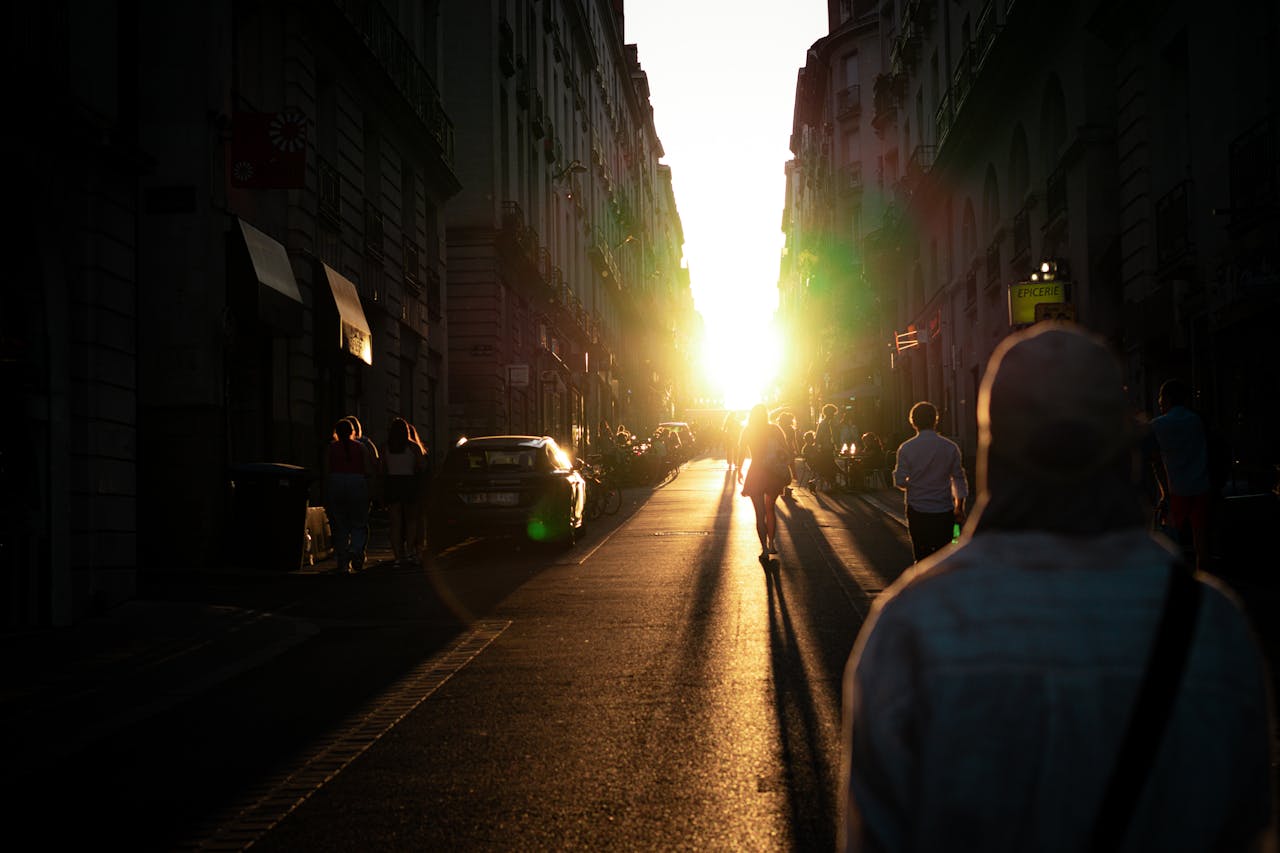 Discover an enchanting city street at sunset with silhouettes and dramatic sunlight.